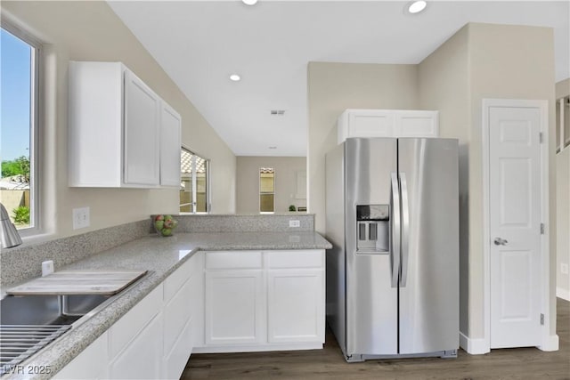 kitchen with sink, white cabinets, light stone counters, dark hardwood / wood-style floors, and stainless steel refrigerator with ice dispenser