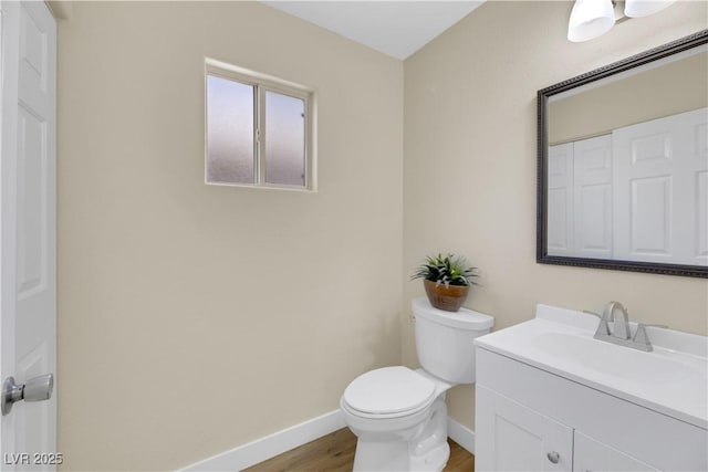 bathroom featuring toilet, hardwood / wood-style floors, and vanity