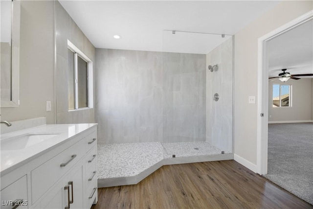 bathroom with vanity, walk in shower, ceiling fan, and hardwood / wood-style flooring