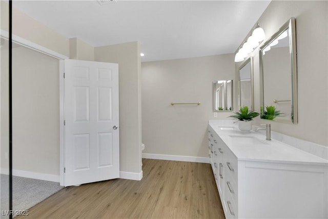 bathroom featuring toilet, vanity, and hardwood / wood-style floors