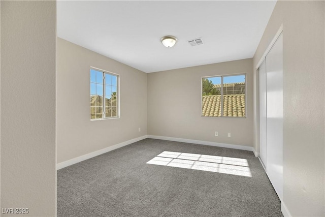 unfurnished room featuring dark colored carpet