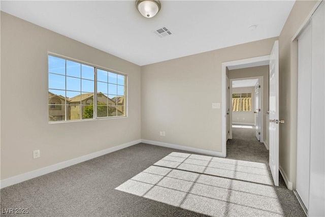 unfurnished bedroom with a closet and dark carpet