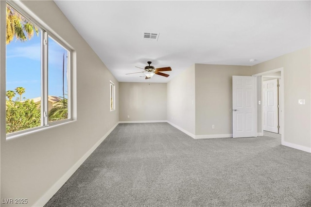 carpeted spare room featuring ceiling fan and a wealth of natural light