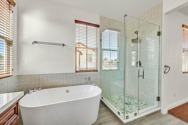 bathroom featuring a wealth of natural light, vanity, and shower with separate bathtub