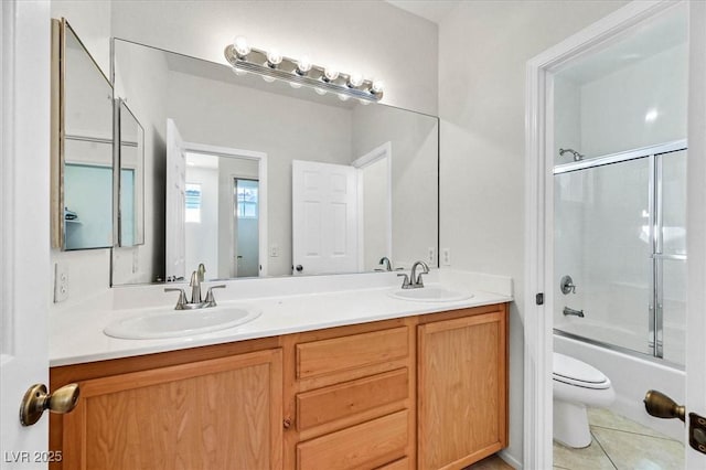 full bathroom with tile patterned flooring, shower / bath combination with glass door, vanity, and toilet