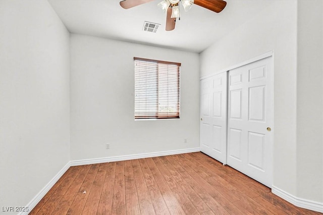 unfurnished bedroom featuring ceiling fan, light hardwood / wood-style floors, and a closet