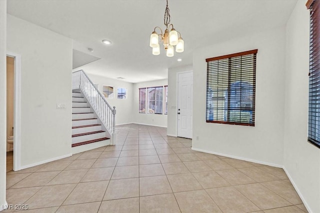 tiled foyer with a chandelier