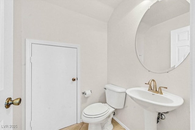 bathroom featuring vaulted ceiling, tile patterned floors, and toilet