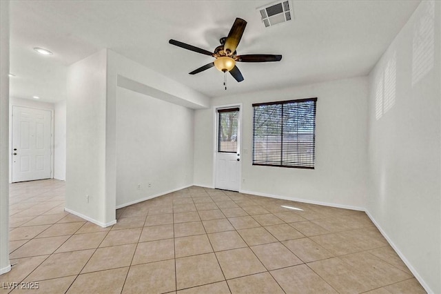 tiled spare room featuring ceiling fan