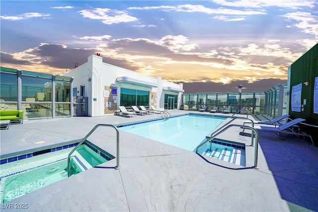 pool at dusk featuring a community hot tub and a patio area