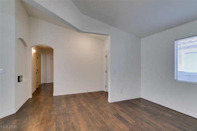 unfurnished room featuring lofted ceiling and dark wood-type flooring