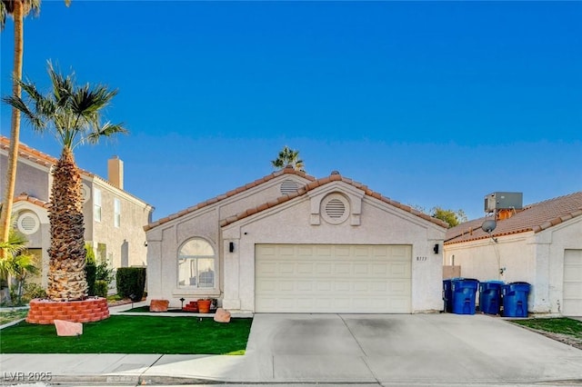 mediterranean / spanish house featuring central AC and a garage