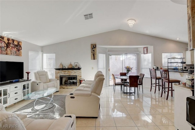 tiled living room featuring a fireplace and vaulted ceiling