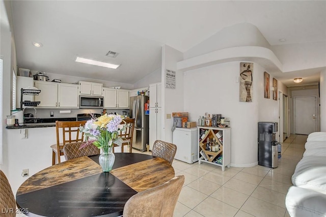 tiled dining room with vaulted ceiling