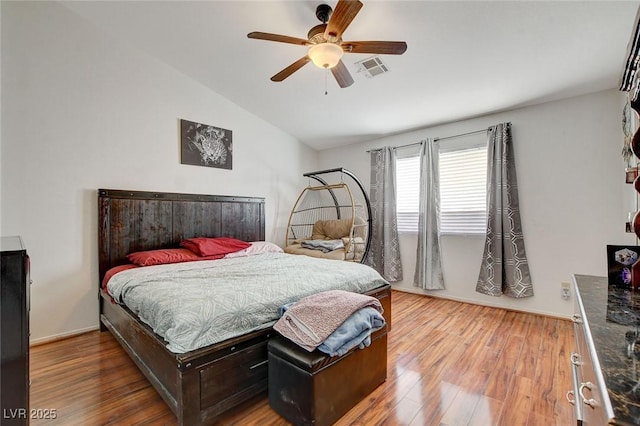 bedroom with ceiling fan, vaulted ceiling, and hardwood / wood-style flooring