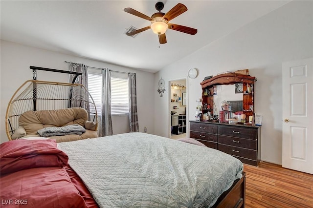 bedroom with ceiling fan, vaulted ceiling, and light hardwood / wood-style flooring