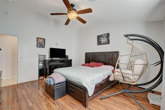 bedroom with ceiling fan, vaulted ceiling, and wood-type flooring