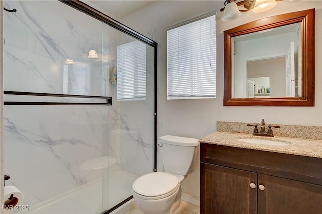 bathroom with an enclosed shower, vanity, and toilet