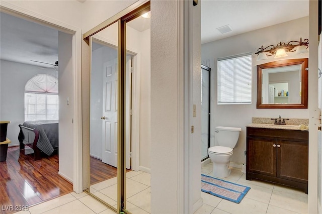 bathroom with ceiling fan, tile patterned flooring, vanity, and toilet