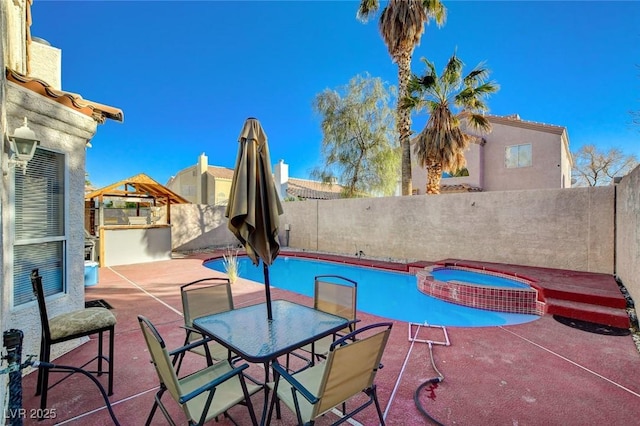 view of swimming pool featuring a patio and an in ground hot tub