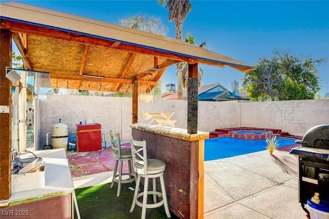 view of patio / terrace with a gazebo, exterior bar, and a swimming pool with hot tub