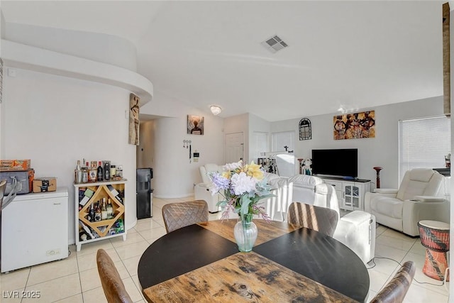 dining space featuring lofted ceiling and light tile patterned floors