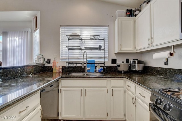 kitchen with black appliances, lofted ceiling, white cabinetry, dark stone countertops, and sink