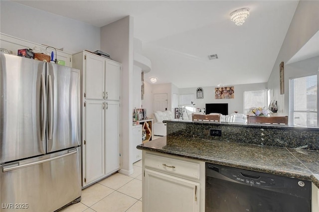 kitchen with stainless steel refrigerator, light tile patterned floors, dark stone counters, white cabinets, and black dishwasher