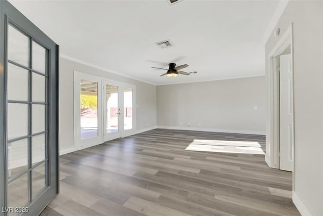 empty room with french doors, ceiling fan, crown molding, and wood-type flooring