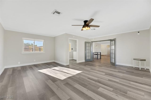 unfurnished living room featuring ceiling fan, ornamental molding, wood-type flooring, and french doors