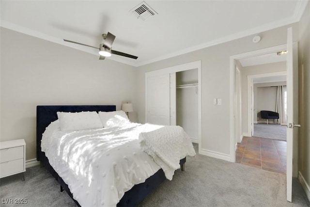 carpeted bedroom featuring ceiling fan, a closet, and crown molding