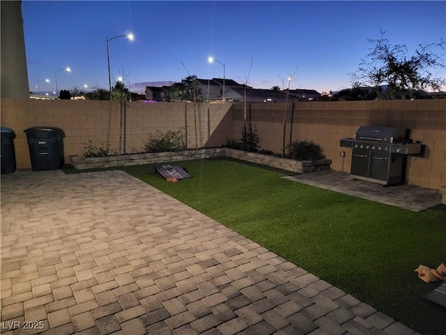 yard at dusk featuring a patio area