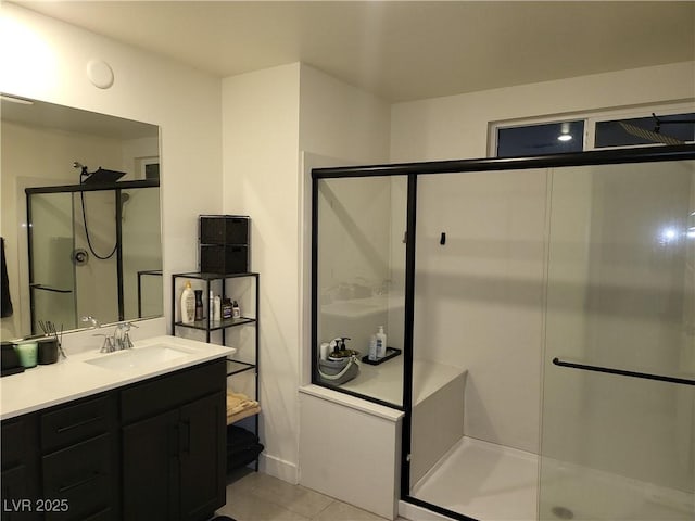 bathroom with a shower with door, tile patterned floors, and vanity