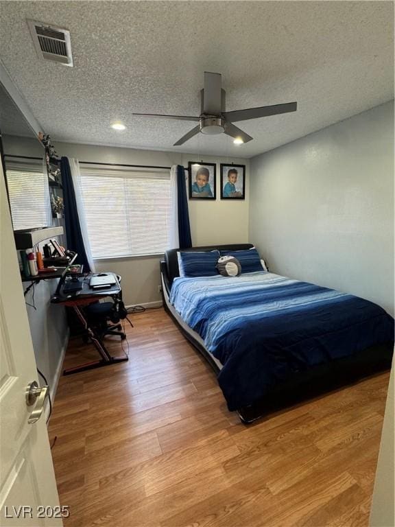 bedroom featuring a textured ceiling, ceiling fan, and hardwood / wood-style flooring