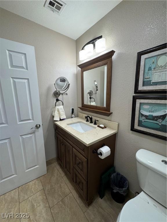 bathroom featuring tile patterned floors, vanity, and toilet