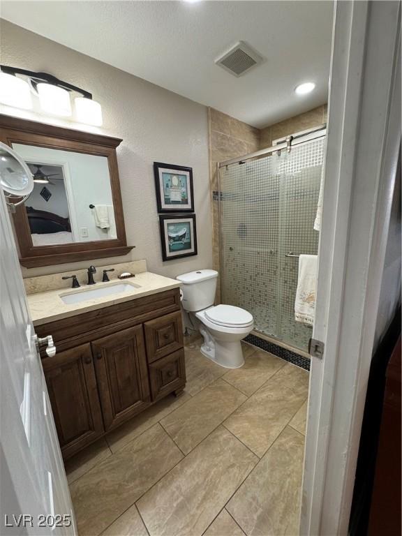 bathroom with toilet, walk in shower, and vanity