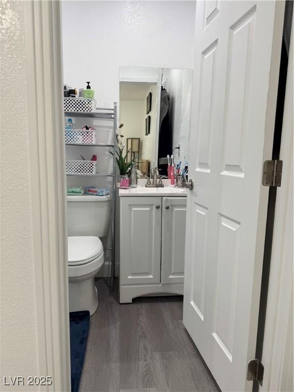 bathroom featuring toilet, vanity, and hardwood / wood-style flooring