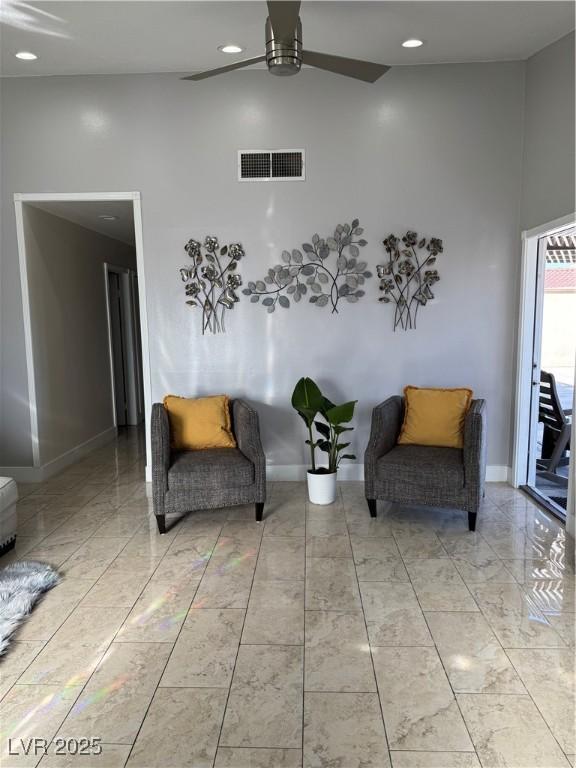 sitting room featuring a high ceiling and ceiling fan