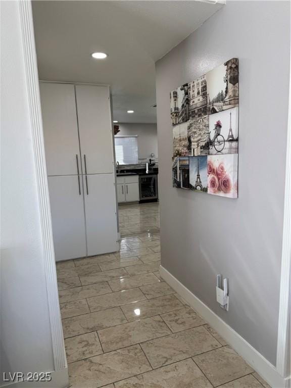 hallway featuring sink and wine cooler