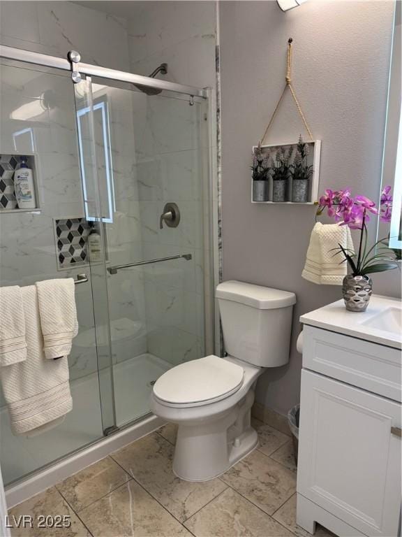 bathroom with toilet, a shower with door, and vanity