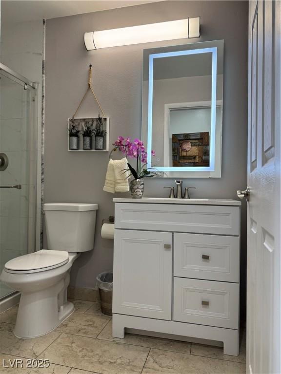 bathroom featuring toilet, an enclosed shower, vanity, and tile patterned floors