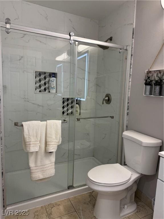 bathroom with toilet, vanity, tile patterned floors, and a shower with shower door