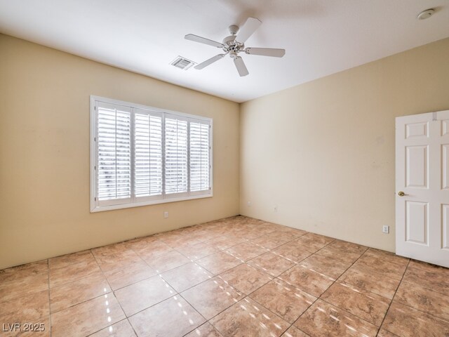 tiled spare room with ceiling fan