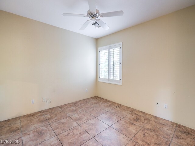 empty room with ceiling fan and light tile patterned floors