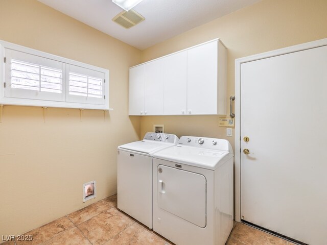 laundry room with washing machine and clothes dryer and cabinets