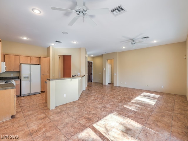 kitchen featuring ceiling fan, light brown cabinetry, kitchen peninsula, and white appliances