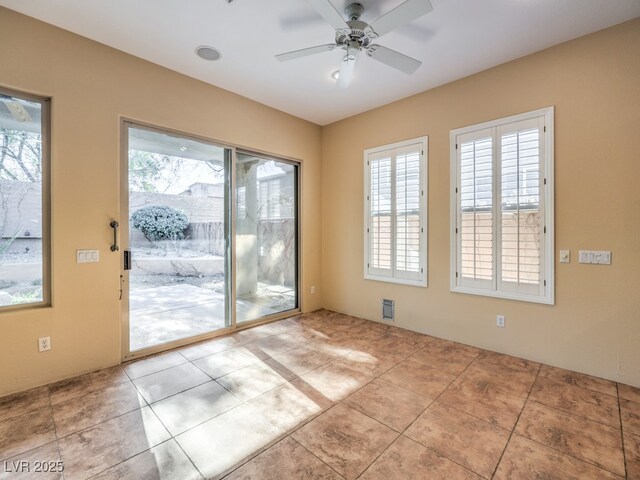 doorway featuring ceiling fan and light tile patterned flooring