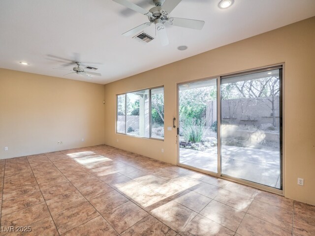 tiled spare room featuring ceiling fan