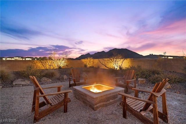 patio terrace at dusk with a mountain view and an outdoor fire pit