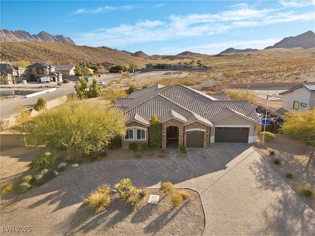 view of front of home with a garage and a mountain view